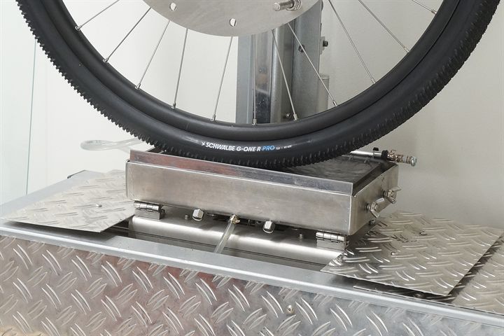 Schwalbe G-One R Pro (black) road bike tire on a grip test machine