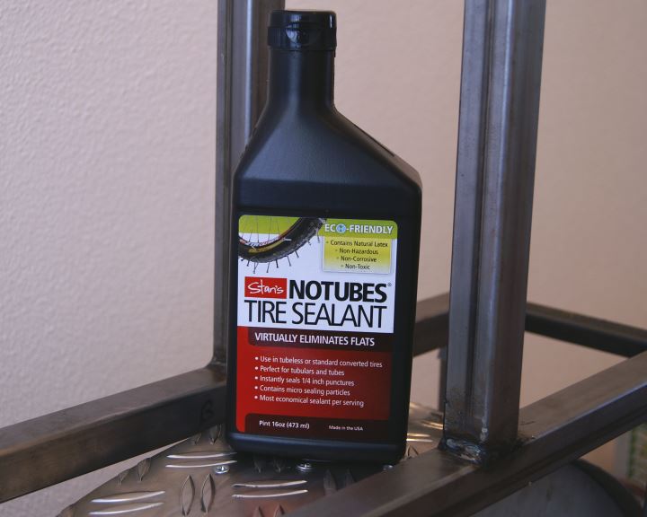 Bottle of Stan's NoTubes tubeless sealant on a rolling resistance test machine